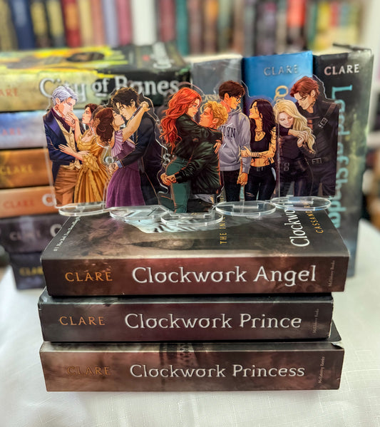A set of 'Shadowhunter' characters  stands on top of three other Clockwork books, with acrylic character stands displaying characters from the series in the background.